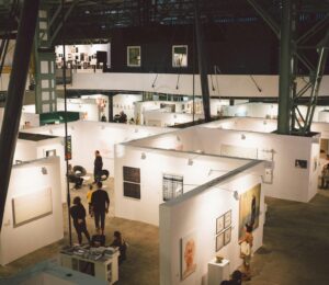 Art exhibition showcasing diverse paintings and installations in a spacious Budapest gallery.